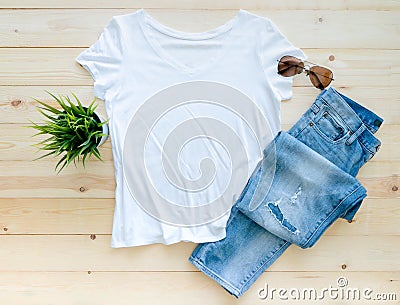 Flat lay, White tshirt mockup jeans and sunglasses on brown wooden background. Template Stock Photo
