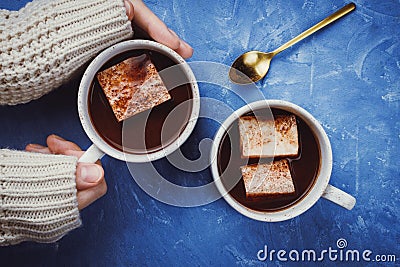 Flat lay of woman`s hands in sweater and two cups of cocoa or hot chocolate Stock Photo