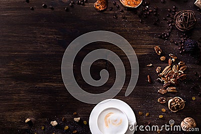 Flat lay wooden background dark brown wood. A cappuccino cup, sprinkled sugar, nuts Stock Photo
