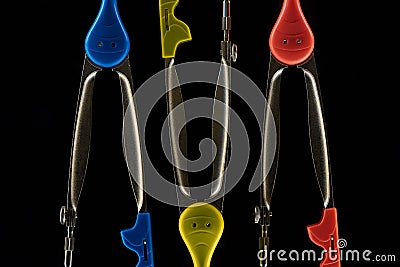 Flat lay of yellow, blue and red compasses isolated on black . Stock Photo