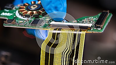 Flat plastic strip flexible cable on printed circuit board on a dark background Stock Photo