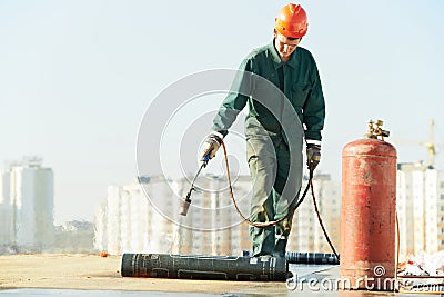 Flat roof covering repair works with roofing felt Stock Photo