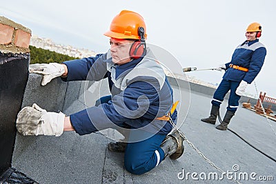 Flat roof installation. Heating and melting bitumen roofing felt Stock Photo