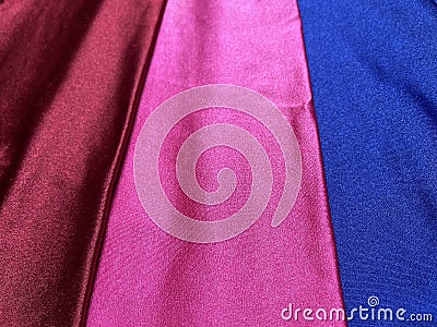 Flat surface of maroon, pink and blue shiny fabric Stock Photo