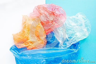 Flatlay colorful plastic bags in a garbage bag on a blue and white background. Sorting of polyethylene waste. Save the Stock Photo