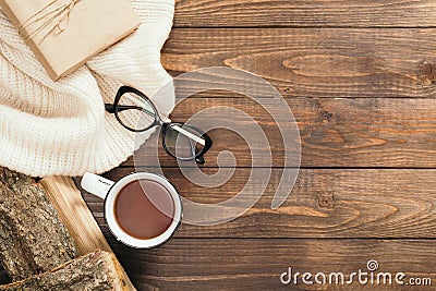 Flatlay composition with red scarf, cup of tea, firewood, book on wooden desk table. Hygge style, cozy autumn or winter holiday Stock Photo