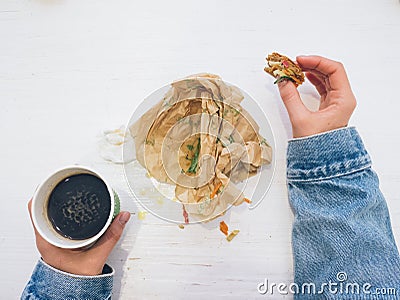 Flatlay of hands with coffee and eaten sandwich Stock Photo