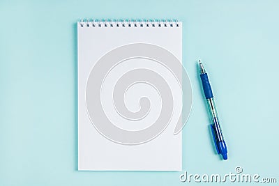 Flatlay notebook and pen on a table on a blue background. Stock Photo