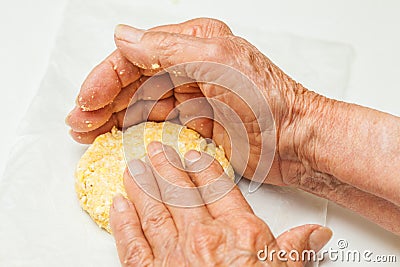 Flatten the dough balls to form the arepa typical shape Stock Photo