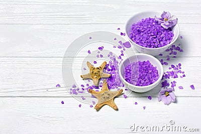 Flavored purple sea salt crystals with violet flower and starfishes on white Stock Photo