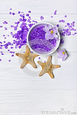 Flavored purple sea salt crystals with violet flower and starfishes on white Stock Photo