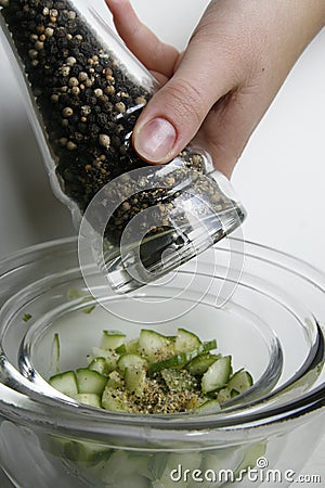 Flavoring the fresh cucumber salad Stock Photo