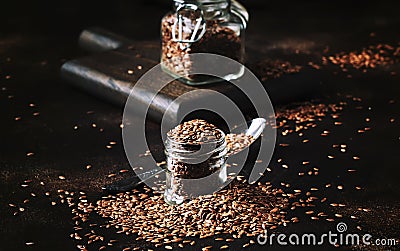 Flax seeds in glass jar, brown kitchen table background, selective focus Stock Photo