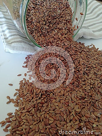 Flax seeds in the glass jar on white background, vintage color tone Stock Photo