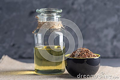 Flax seeds in a pile and linseed golden oil in a glass bottle on Stock Photo