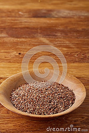 Flax seeds in a plate on wooden background, top view, close-up. Stock Photo