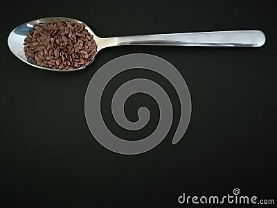 Flax seeds in the spoon on black background, vintage color tone Stock Photo