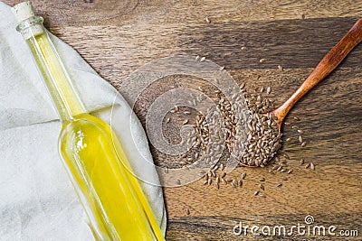 Flaxseed in a wooden spoon and linseed oil in a wooden spoon on a wooden background Stock Photo