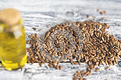 Flaxseeds, jar with linseeds oil and spoon on gray table. Stock Photo