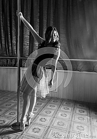 Flexible ballet dancer stretching in retro style. Ballerina dances near pole. black and white Stock Photo