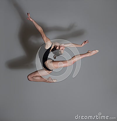 Flexible gymnast. Girl makes an expressive jump Stock Photo