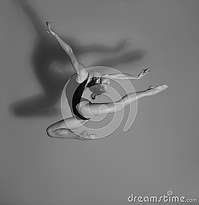 Flexible gymnast. Girl makes an expressive jump Stock Photo