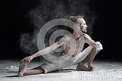 Flexible yoga man doung wide side lunge or utthita namaskarasana. Stock Photo