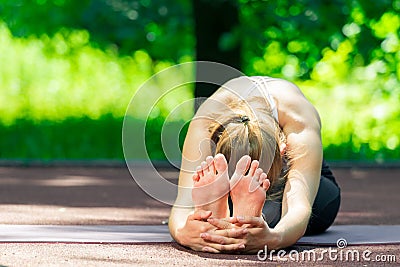 flexible yoga trainer during stretching, summer outdoor Stock Photo
