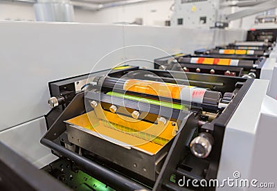 Flexographic printing machine with an ink tray, ceramic anilox roll, doctor blade and a print cylinder with polymer relief plate. Stock Photo