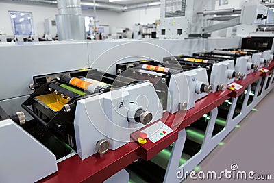 Flexographic printing machine with an ink tray, ceramic anilox roll, doctor blade and a print cylinder with polymer relief plate. Stock Photo