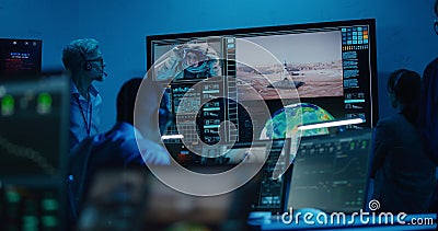 Flight control operators monitor space mission on computers in command center Stock Photo
