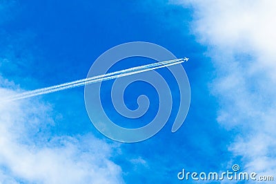 Flight over the city. Clear blue sky is cut by the plane. Stock Photo