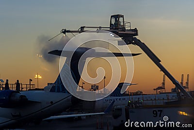 Flight safety with airport staff preparing airplane for the flight deicing the wing of the aircraft at winter from Editorial Stock Photo