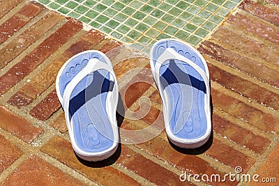 Flip flop slippers beside a pool shower Stock Photo