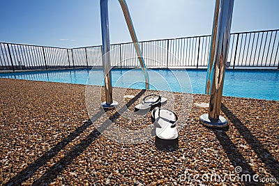 Flip flops at a pool edge nobody Stock Photo