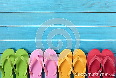 Flip flops in a row with blue beach deck background, copy space Stock Photo