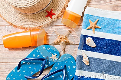 Flip flops, straw hat, starfish, sunscreen bottle, body lotion spray on wooden background top view . flat lay summer beach sea Stock Photo