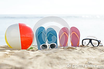 Flipflops, beach ball, sunglasses, and snorkel on the sand Stock Photo