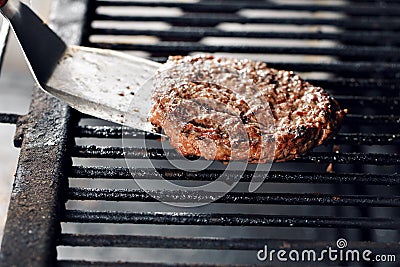 Flipping Hamburgers on the Grill with a Spatula. selective fosuc, close-up Stock Photo