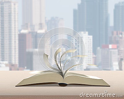 Flipping pages of open book on wood table with city building vie Stock Photo