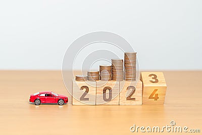 2023 flipping to 2024 year block with car model and Coins Money stack for deposit and Automobile Tax. Money Saving, Car Insurance Stock Photo