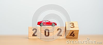 2023 flipping to 2024 year block with car model on table. Automobile Tax, Car Insurance, Financial, vehicle Repair and Maintenance Stock Photo