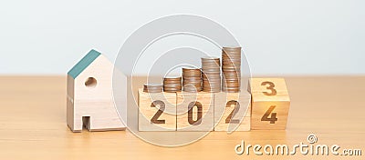 2023 flipping to 2024 year block with house model and Coins stack. real estate, Home loan, tax, investment, mortgage, financial, Stock Photo