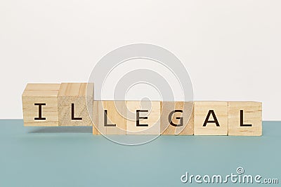 Flipping two wooden cube to change the word Legal to Illegal on neutral background Stock Photo