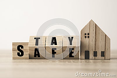 Flipping wooden blocks change wording stay and safe with wooden home. Stay home to prevent COVID 19 out break Stock Photo