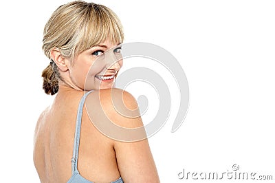 Flirtatious woman turning back and passing a smile Stock Photo