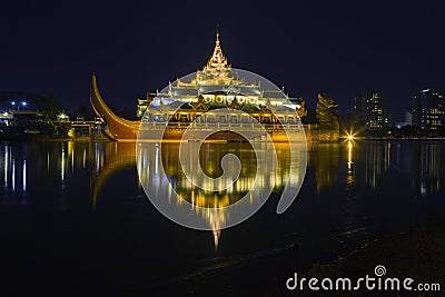 Floating Barge Karaweik Hall on Kandawgyi lake at twilight Stock Photo