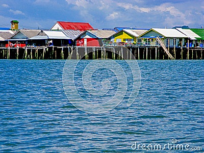 Floating fisherman village on man-made island with colorful roof and vintage houses on the blue sea with clear blue sky. Stock Photo