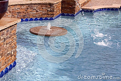 Floating fountain within a swimming pool Stock Photo