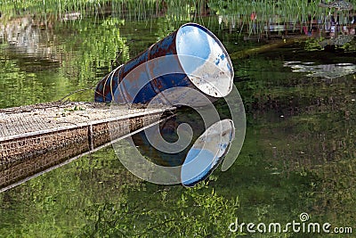 Metal barrel float in wetland lake, reflection on a water surface Stock Photo